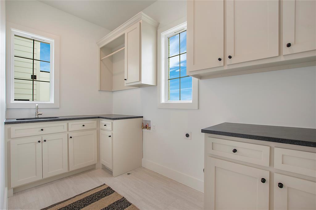 1031 Mobile Street Dallas, TX 75208 - Photo 17 of 28 a kitchen with white cabinets and a window