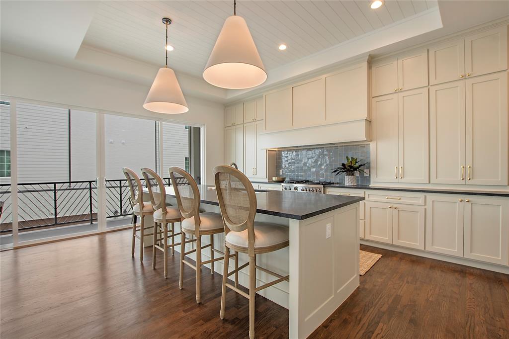 1031 Mobile Street Dallas, TX 75208 - Photo 4 of 28 a kitchen with stainless steel appliances granite countertop a stove top oven a sink a dining table and chairs with wooden floor