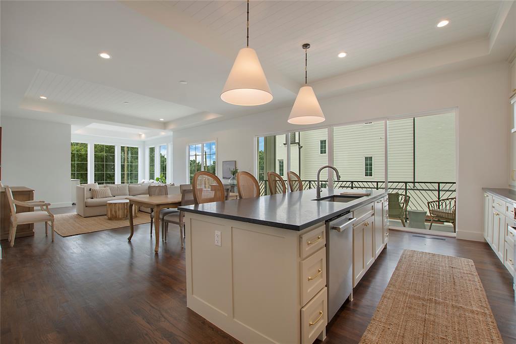 1031 Mobile Street Dallas, TX 75208 - Photo 6 of 28 a kitchen with granite countertop a stove a sink a dining table and chairs with wooden floor
