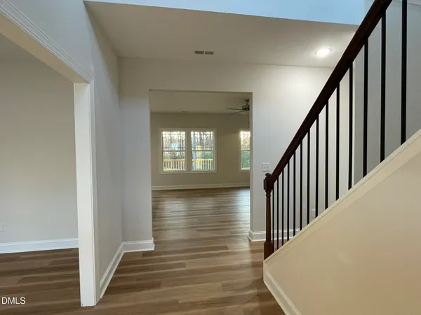 a view of a hallway with wooden floor and staircase