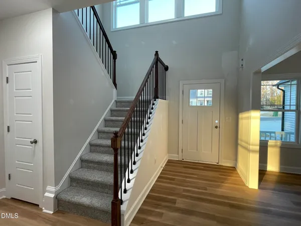a view of a hallway with wooden floor and staircase