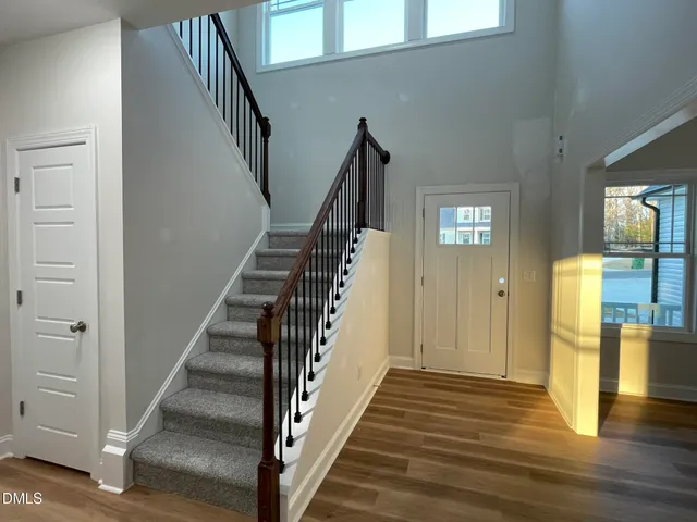 a view of a hallway with wooden floor and staircase