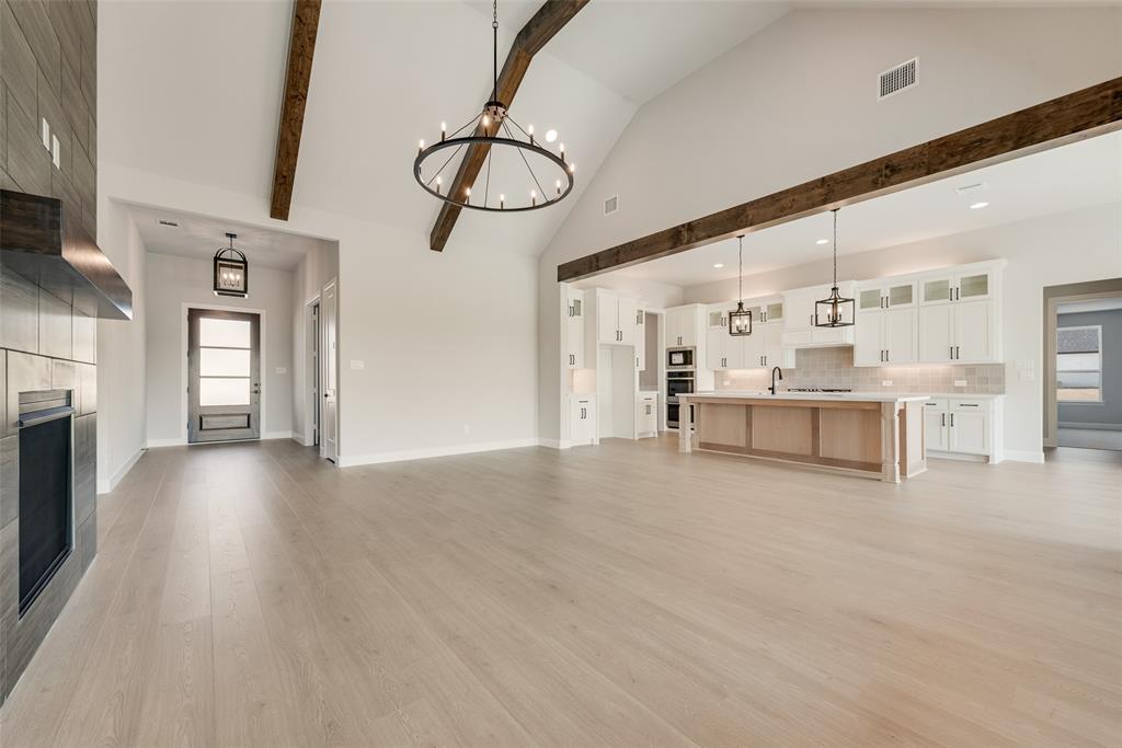 5291 Sunset Road Caddo Mills, TX 75135 - Photo 12 of 39 a view of a livingroom with furniture a fireplace wooden floor and chandelier