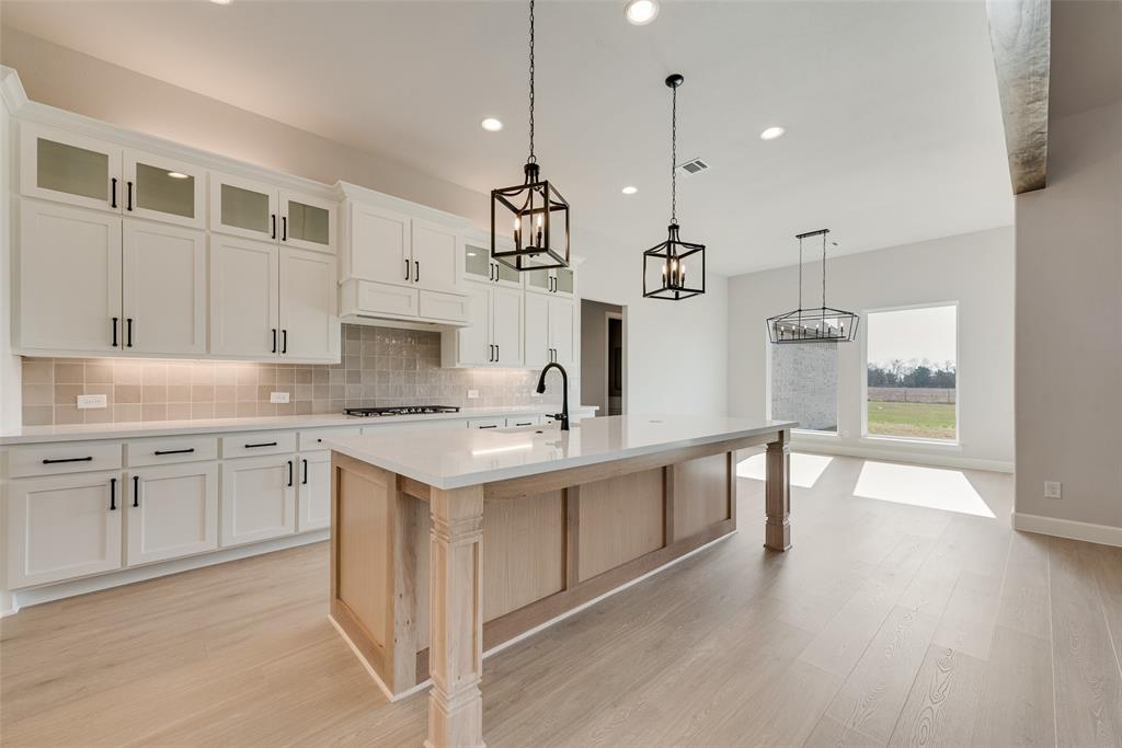 5291 Sunset Road Caddo Mills, TX 75135 - Photo 13 of 39 a kitchen with a sink stove and wooden floor