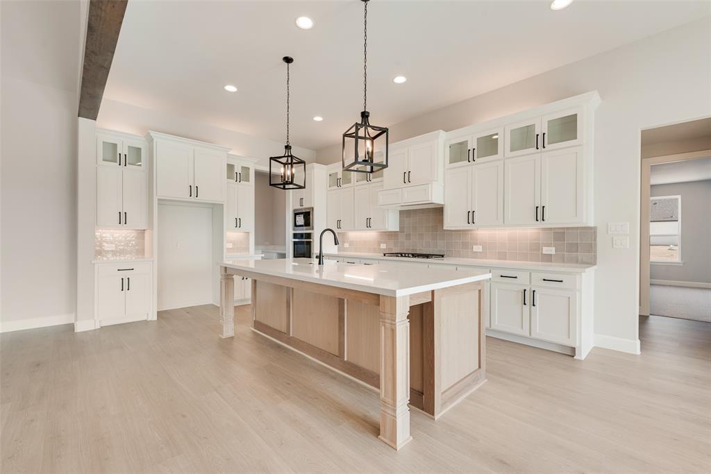 5291 Sunset Road Caddo Mills, TX 75135 - Photo 17 of 39 a large kitchen with kitchen island a sink a stove a refrigerator and white cabinets