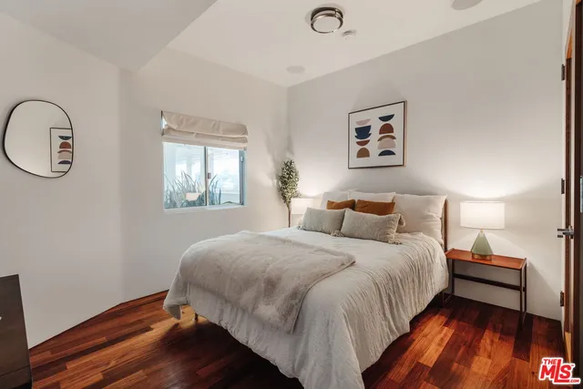 a bedroom with a bed and wooden floor