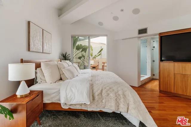 a bedroom with a bed and wooden floor