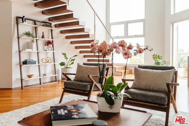 a living room with furniture flowerpot and wooden floor
