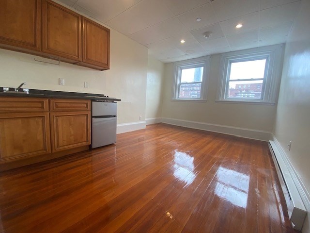 506 Beacon Street, Unit 13 Boston, MA 02215 - Photo 2 of 5 a view of an empty room with wooden floor and a window