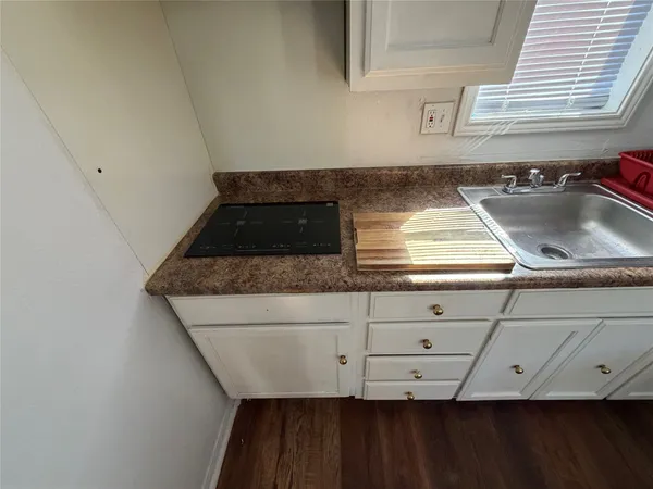 a kitchen with granite countertop a sink a stove and cabinets
