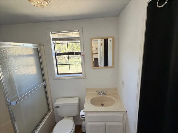 a bathroom with a sink toilet and window