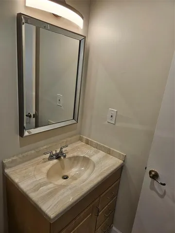 a bathroom with a sink a mirror a toilet and shower