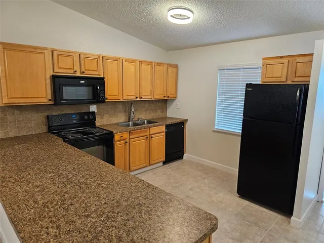 a kitchen with stainless steel appliances granite countertop a stove and a refrigerator