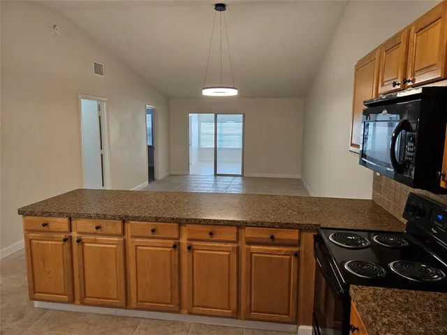 a kitchen with stainless steel appliances granite countertop a stove a sink and a microwave