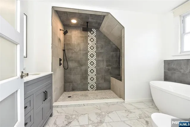 a bathroom with a tub sink and mirror
