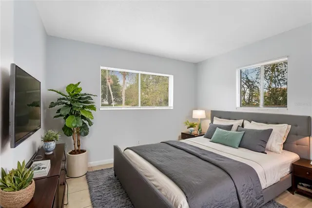 a bedroom with a bed and a potted plant