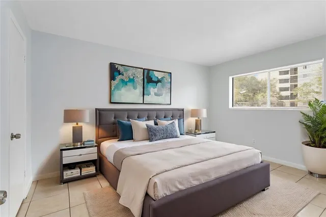 a bedroom with bed and a potted plant