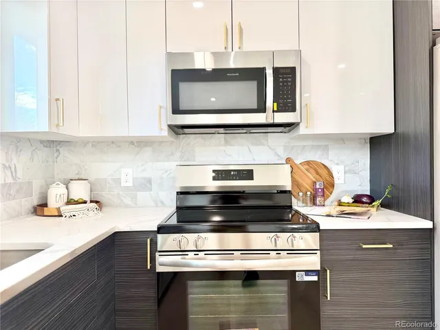 a kitchen with stainless steel appliances granite countertop a stove and a microwave