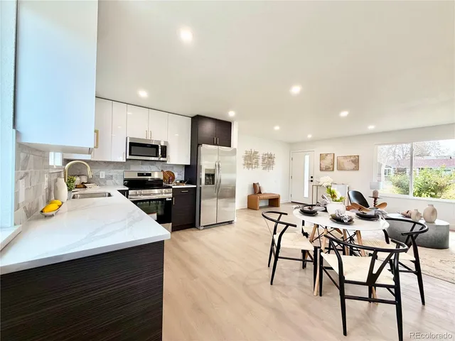 a kitchen with a table chairs microwave and cabinets