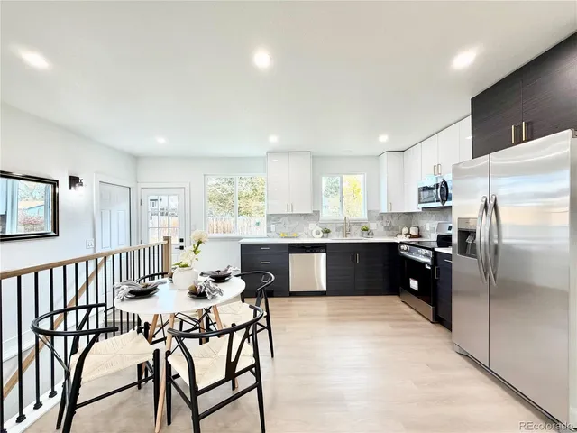 a kitchen with stainless steel appliances kitchen island granite countertop a refrigerator a stove a sink dishwasher with a dining table and chairs