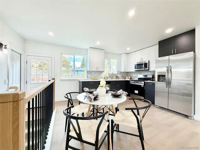 a kitchen with stainless steel appliances kitchen island granite countertop a refrigerator a stove a sink dishwasher with a dining table and chairs