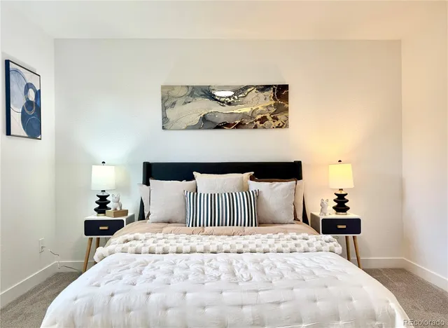 a bedroom with a bed and painting on the wall