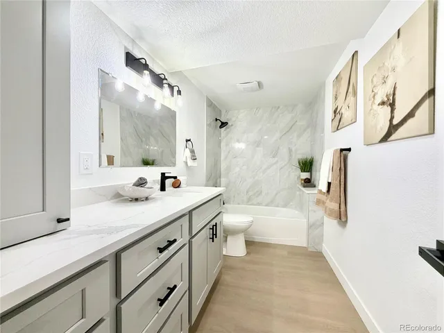 a bathroom with a double vanity sink a toilet a mirror and shower