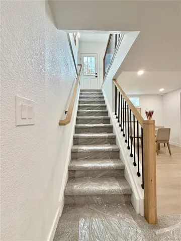 a view of staircase with lots of frames on wall and a view of entryway