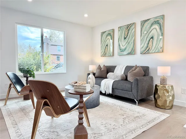 a living room with furniture a rug and wall painting