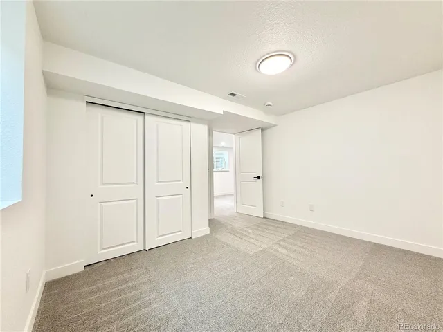 an empty room with a white cabinet and a window