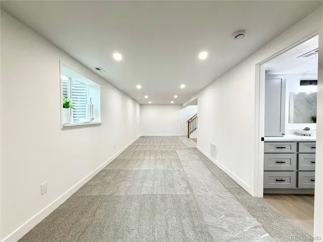 a view of empty room with wooden floor