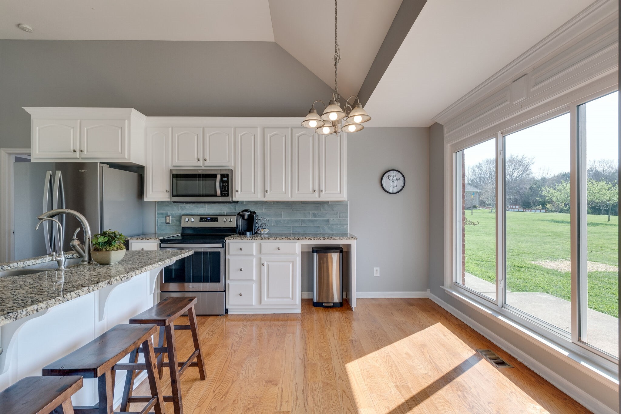 1978 Lasea Road Spring Hill, TN 37174 - Photo 12 of 31 a kitchen with stainless steel appliances granite countertop a stove top oven a sink dishwasher a dining table and chairs with wooden floor
