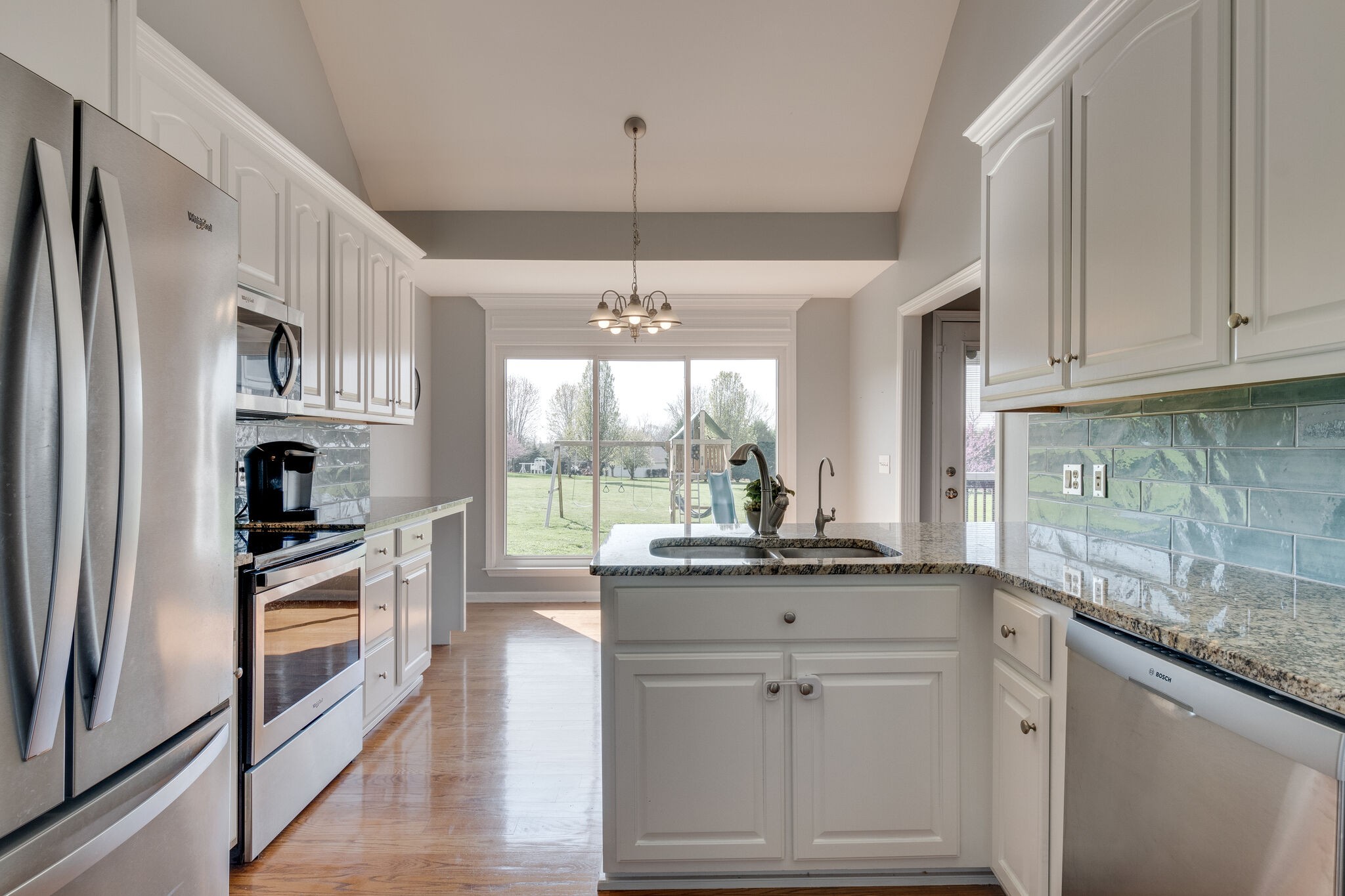 1978 Lasea Road Spring Hill, TN 37174 - Photo 18 of 31 a kitchen with kitchen island granite countertop white cabinets and white appliances