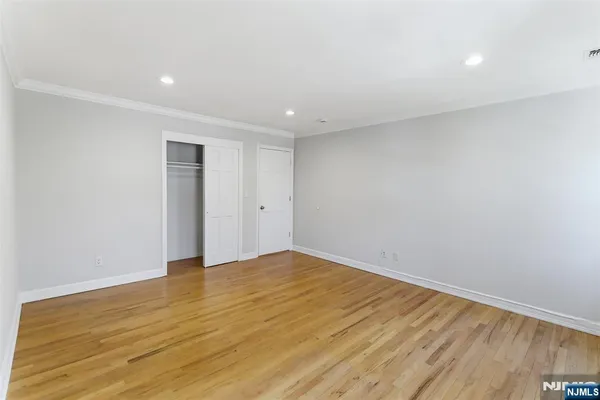 a view of an empty room with wooden floor