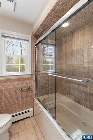 a bathroom with a granite countertop bathtub next to a window