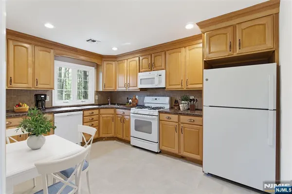 a kitchen with a refrigerator a stove top oven a sink and cabinets
