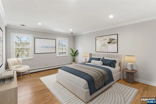 a spacious bedroom with a bed and wooden floor