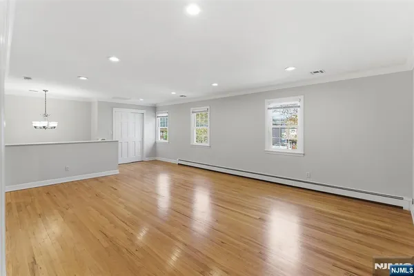 a view of empty room with wooden floor and window