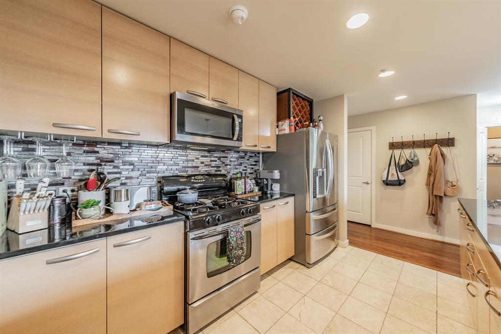 1200 Main Street, Unit 306 Dallas, TX 75202 - Photo 10 of 35 a kitchen with stainless steel appliances a stove a sink and a refrigerator