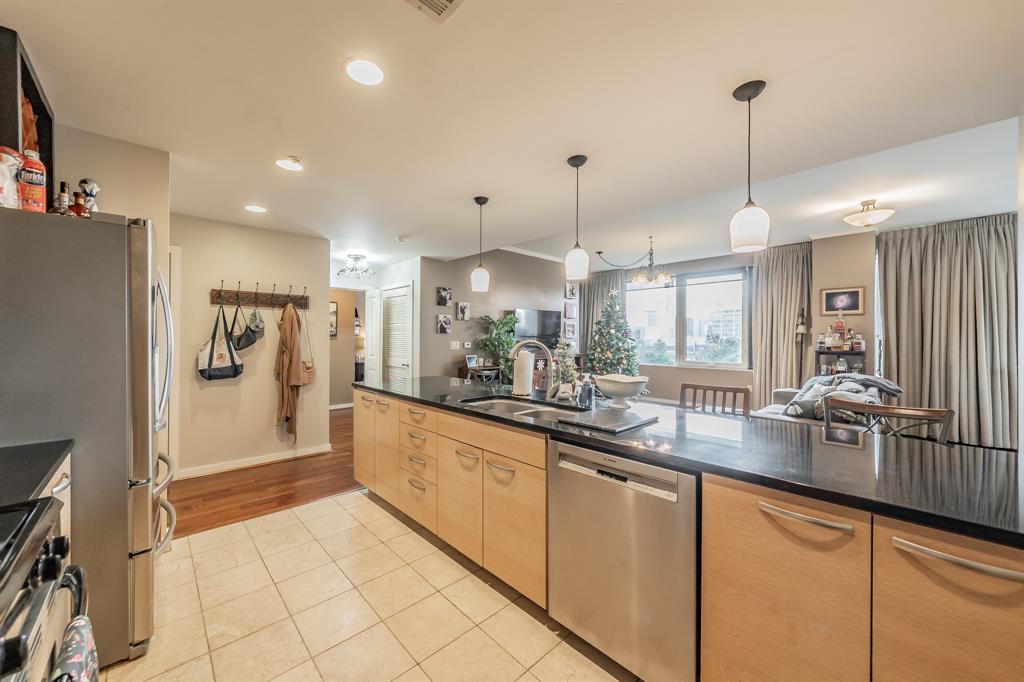 1200 Main Street, Unit 306 Dallas, TX 75202 - Photo 11 of 35 a kitchen with stainless steel appliances granite countertop a refrigerator a oven and white cabinets with wooden floor