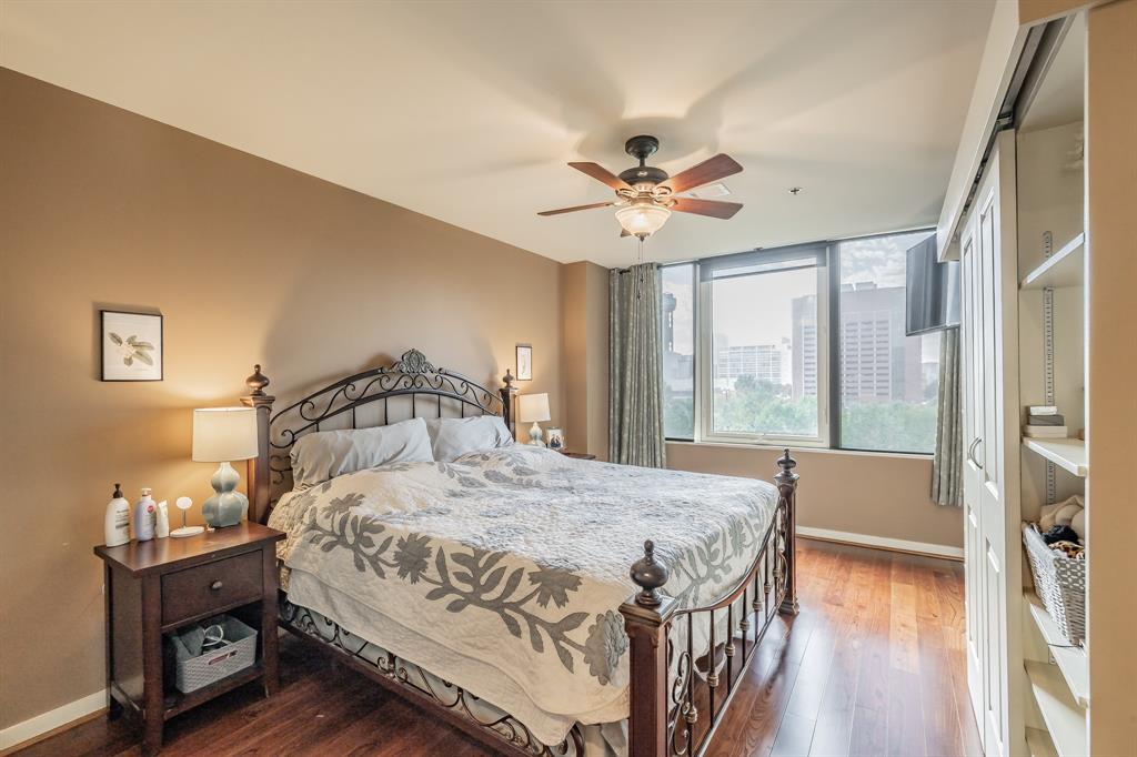 1200 Main Street, Unit 306 Dallas, TX 75202 - Photo 16 of 35 a bedroom with a bed chandelier and a window