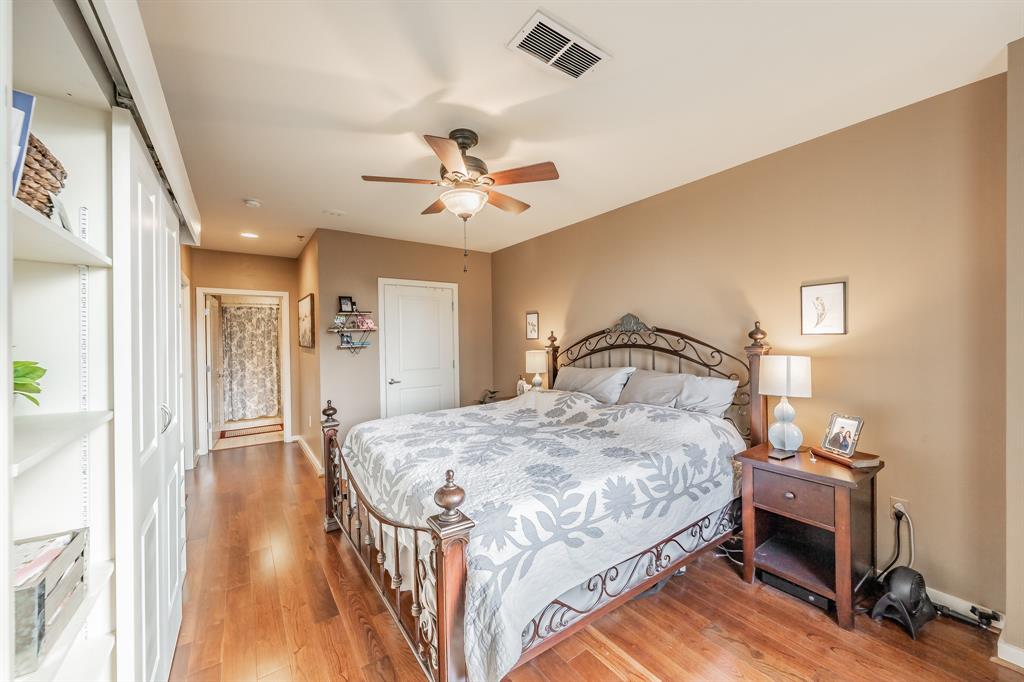 1200 Main Street, Unit 306 Dallas, TX 75202 - Photo 17 of 35 a bedroom with a bed and wooden floor