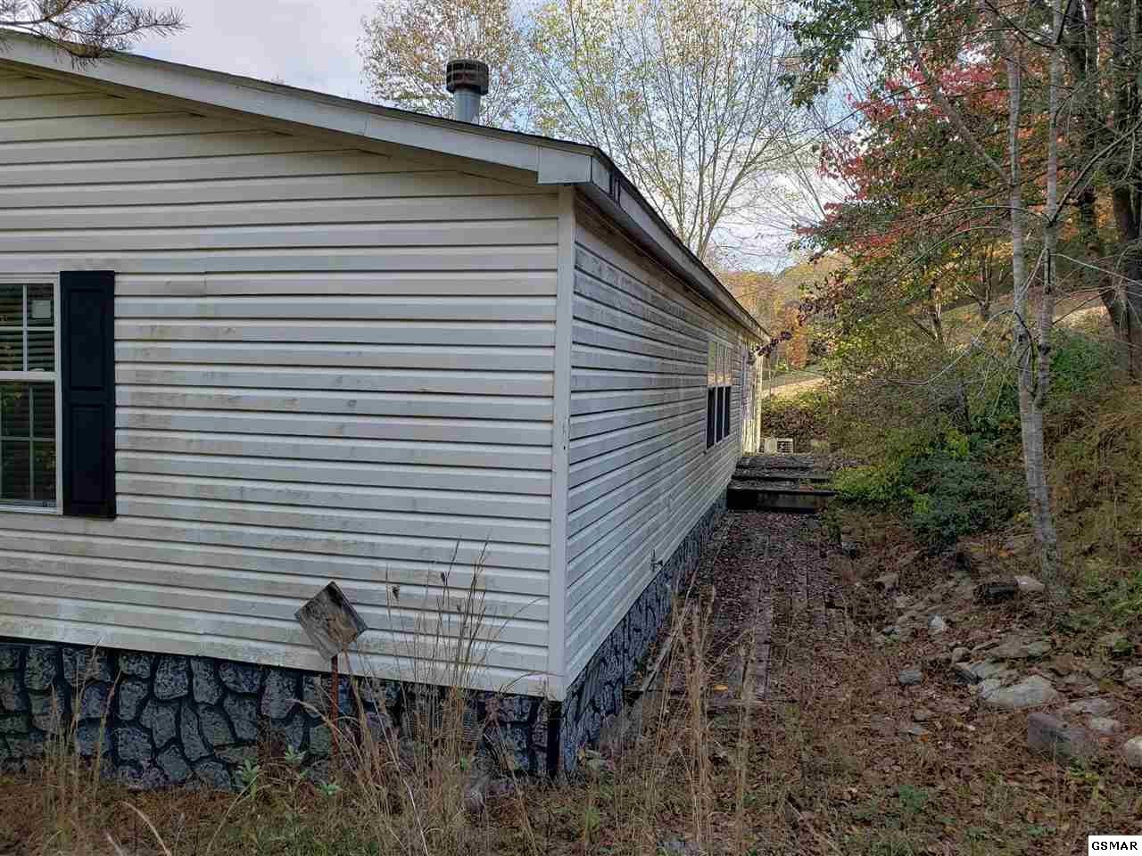1033 Beard Valley Road Maynardville, TN 37807 - Photo 19 of 22 a back view of a house with a yard and garage