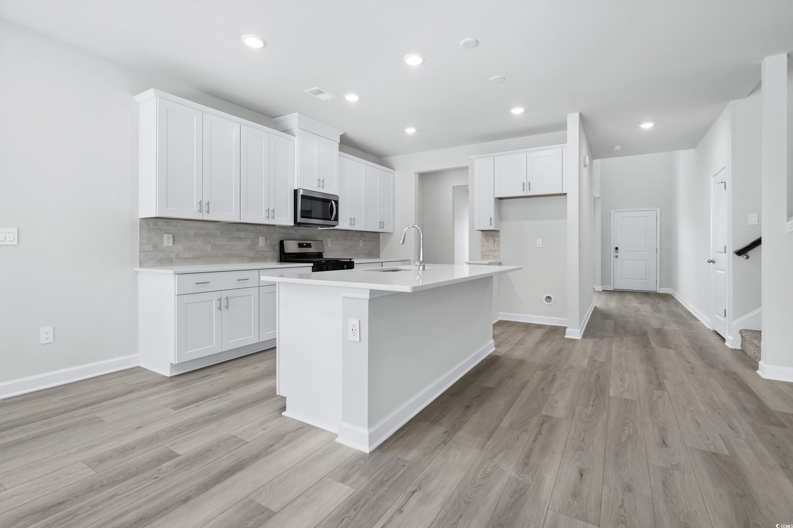 2409 Grand Mdw Drive Longs, SC 29568 - Photo 7 of 40 Kitchen with white cabinetry, a kitchen island wit