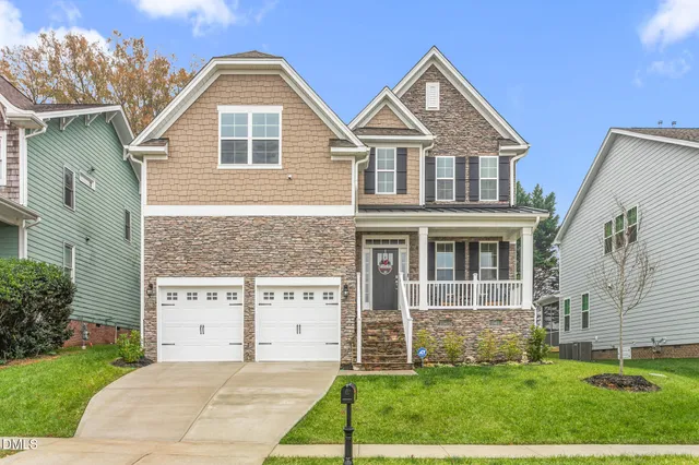 a front view of a house with a yard and garage