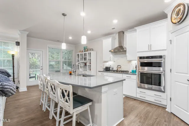 a kitchen with stainless steel appliances kitchen island granite countertop a stove a sink and a refrigerator