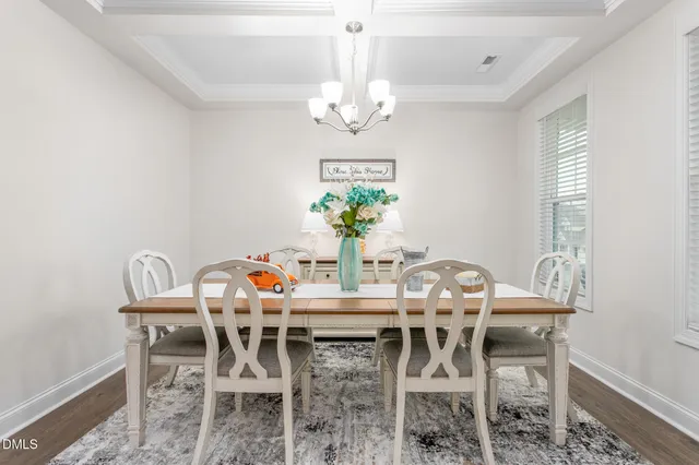 a dining room with furniture a potted plant and a chandelier