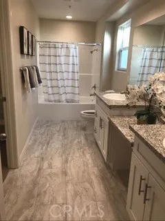 a bathroom with a granite countertop sink a toilet a mirror and shower