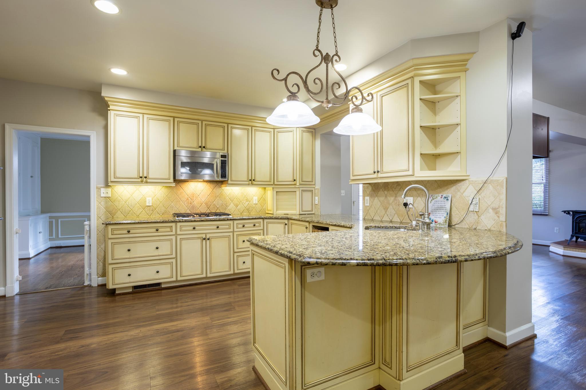 3306 Labyrinth Road Baltimore, MD 21215 - Photo 15 of 66 a kitchen with stainless steel appliances granite countertop a sink a stove and a wooden floors