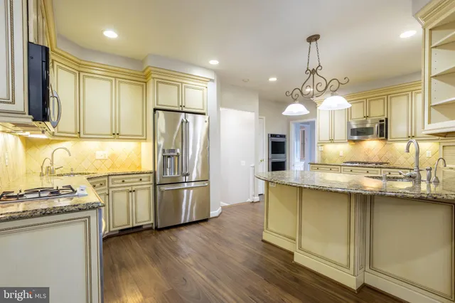 a kitchen with stainless steel appliances granite countertop a stove and a microwave